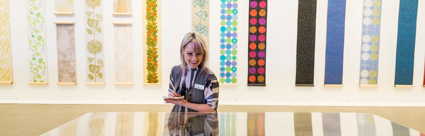 Student looking down at artwork in a glass cabinet