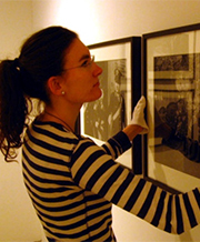 Museology student hanging photographs with white gloves