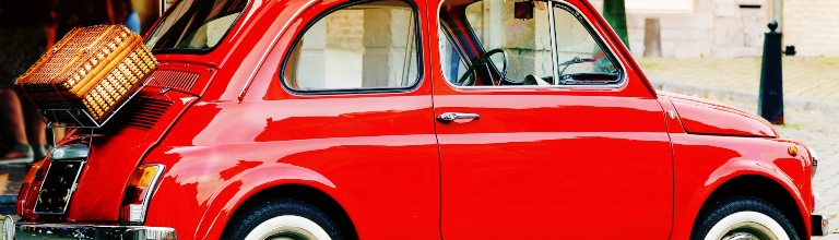 An image of a classic bright red Fiat 500