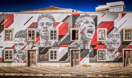 Facade of a house, painted with large portraits of the Portugese footballers Cristiano Ronaldo, Joao Moutinho, Bernardo Silva and William Carvalho.