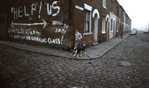 Boy walking a dog in 1980s Manchester on terraced street