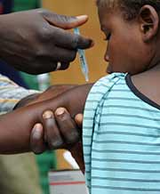 Child being vaccinated by relief worker.