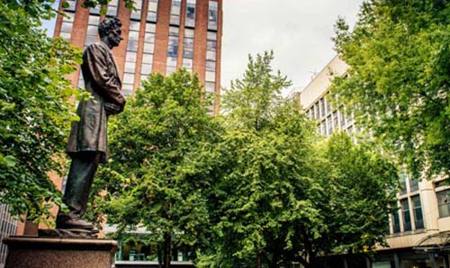 Lincoln statue outside with green trees nearby