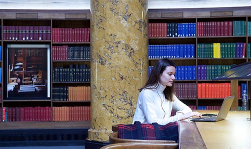 Female student in library working on laptop