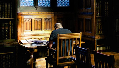 Male sat at a desk in the library studying