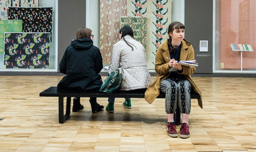 Female sat in art gallery drawing