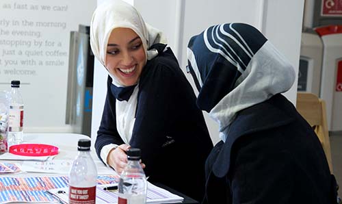 Two students smiling at each other