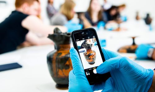 Someone taking a photo of a pot.