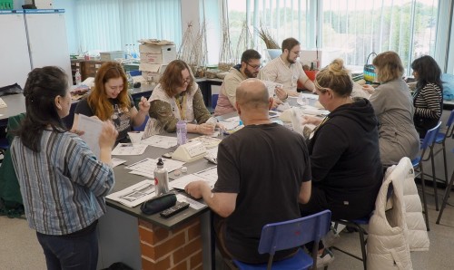 Group of people sat around a table looking at papers.