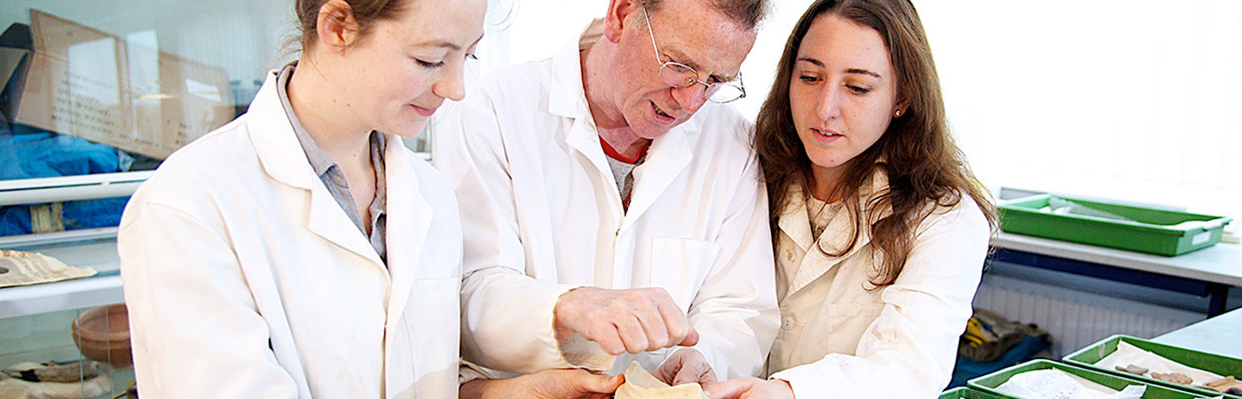 Students with teacher working with fragments from an archaeological dig