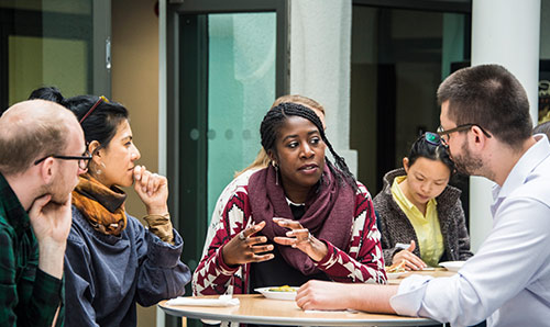 Group of people sat around table talking