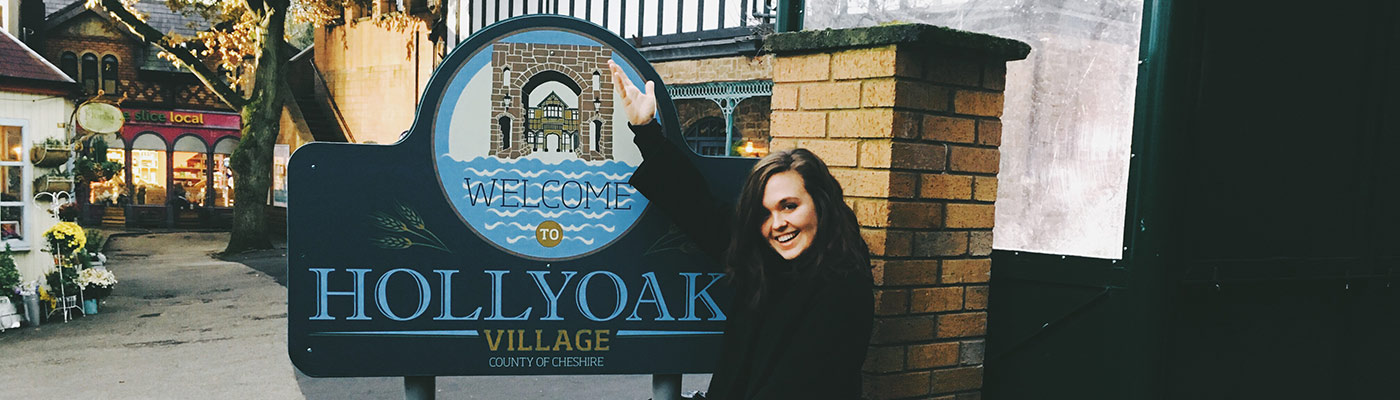 Screenwriting MA student Jessy Kelly next to the Hollyoaks sign