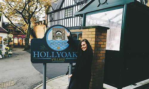 Jessy Keely standing in front of the Hollyoaks sign