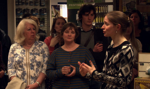 Woman talking to group of people in book store