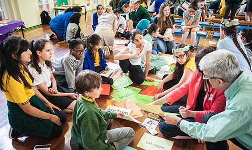 School children sat on floor with teacher