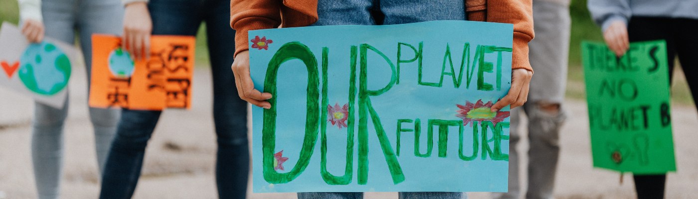 Close up of posters held up by protesters, reading our planet, our future. There is no planet B. Respect your mother earth.