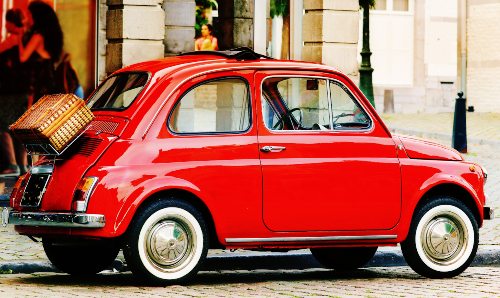 An image of a classic bright red Fiat 500