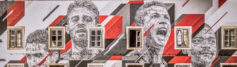 Facade of a house, painted with large portraits of the Portugese footballers Cristiano Ronaldo, Joao Moutinho, Bernardo Silva and William Carvalho.