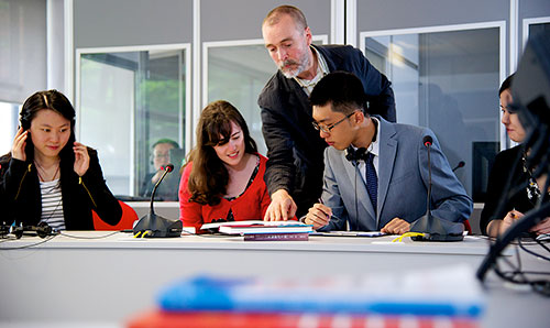 Students with teacher looking over their work