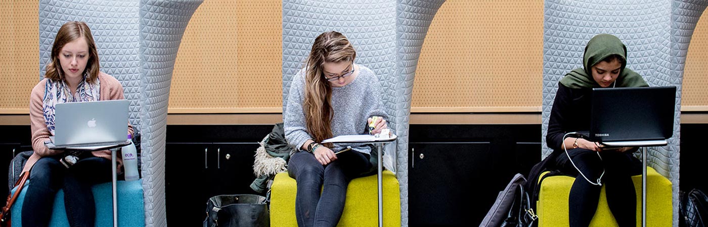 Three people sat on chairs on laptops