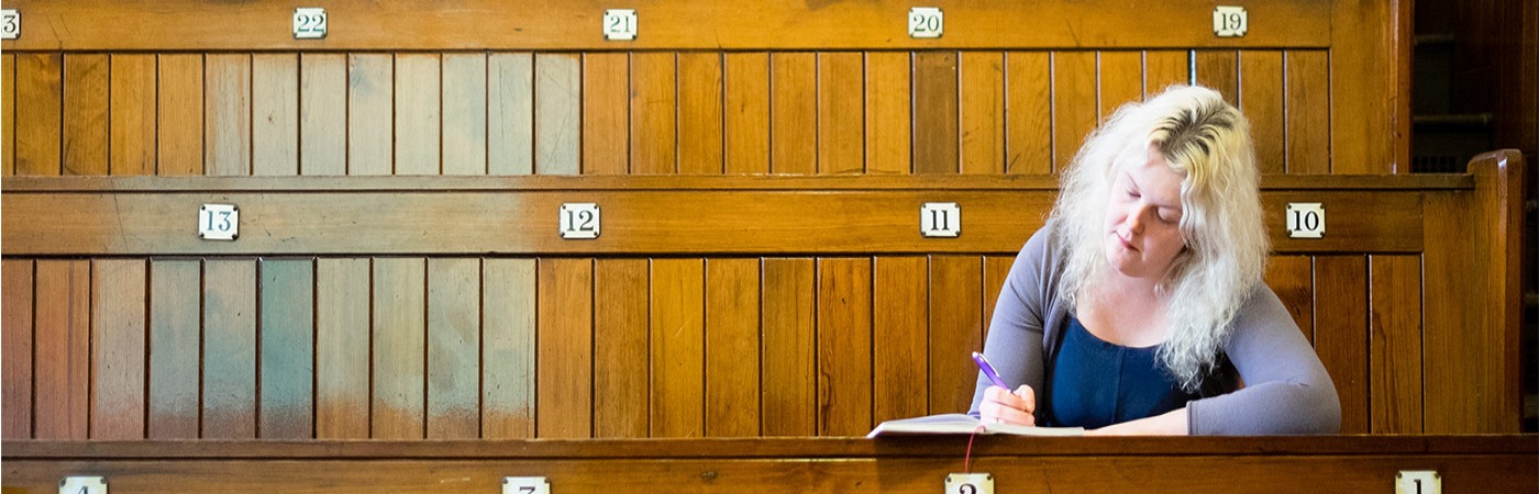 Female student writing in auditorium