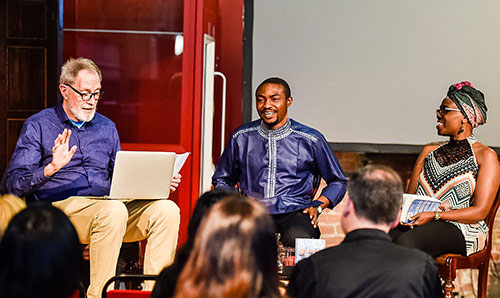 Three speakers on stage giving a talk