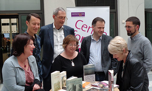 Group of people surrounding table of books