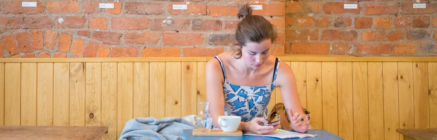 Student in cafe looking at phone.