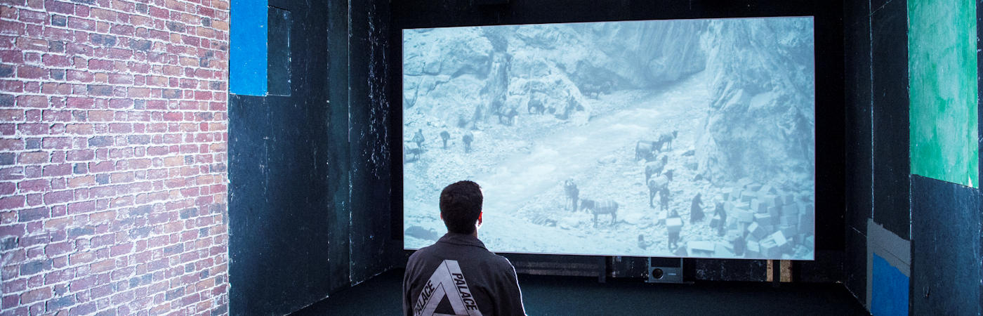 Man viewing film on big screen.