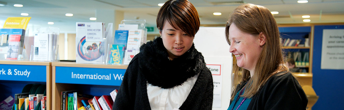 Student looking at leaflet with careers advisor.