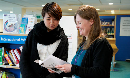 Student looking at leaflet with careers advisor.