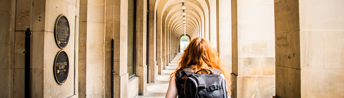 Girl walking through outside corridor