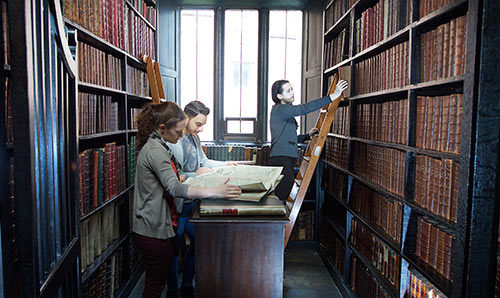 Students looking at books in library