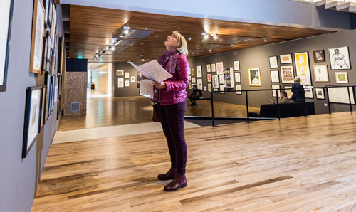 Woman looking at paintings in gallery