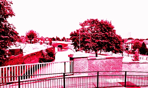 A red-tinted image of a bridge over water