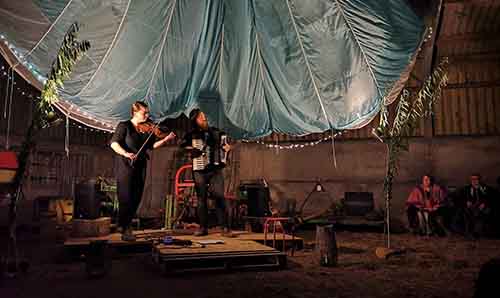 Musicians playing instruments inside a marquee