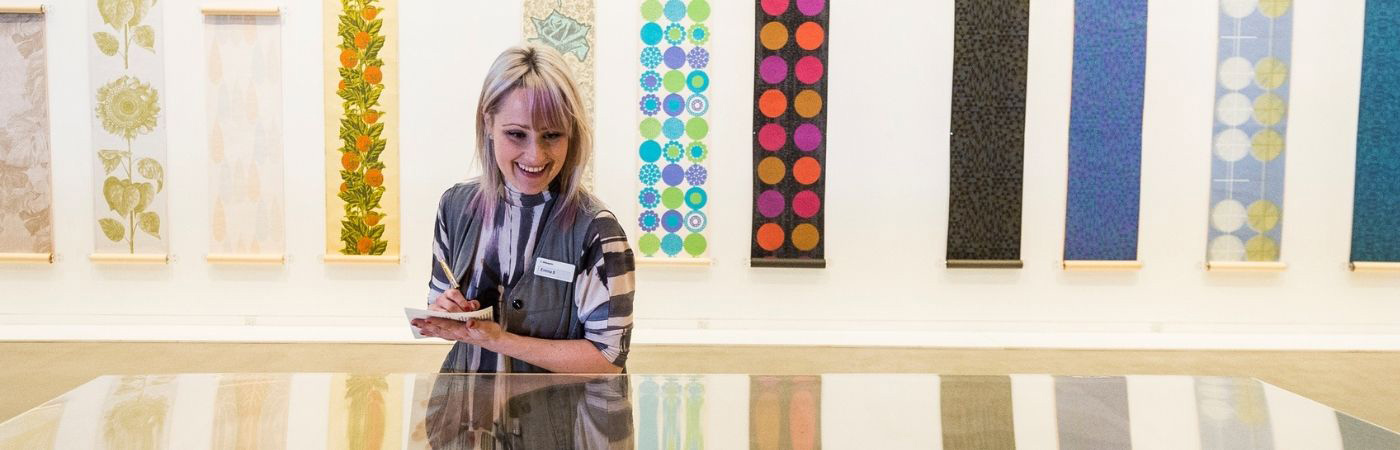 Female student taking notes at an exhibition