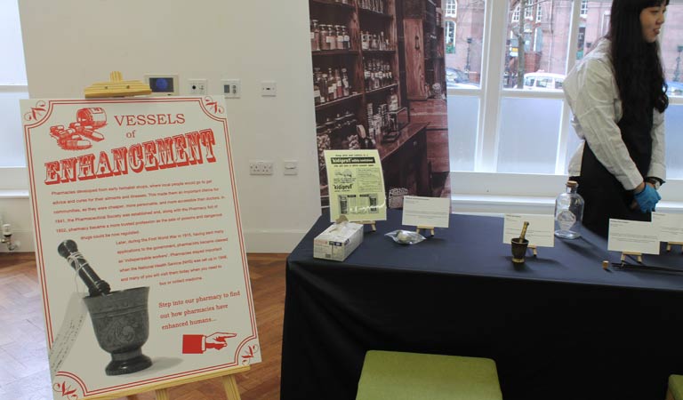 Vessels of enhancement: Photo of the exhibition stand that informs us that pharmacies developed from early herbalist shops.