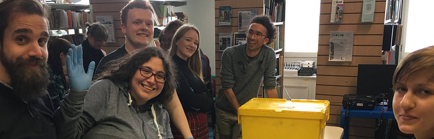 group of students with art handling gloves and a yellow box