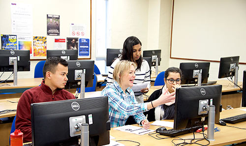 Female teaching students at a computer