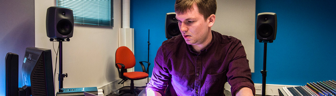 Male student at a mixing desk in the electroacoustic studio