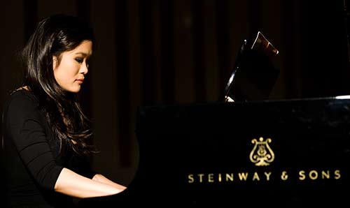 Female student playing piano.