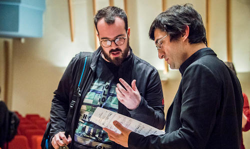 Male student talking to staff about sheet music