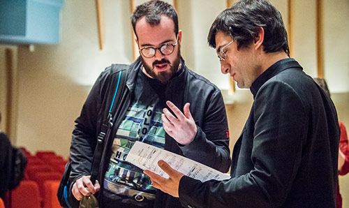 Two men looking at a piece of music