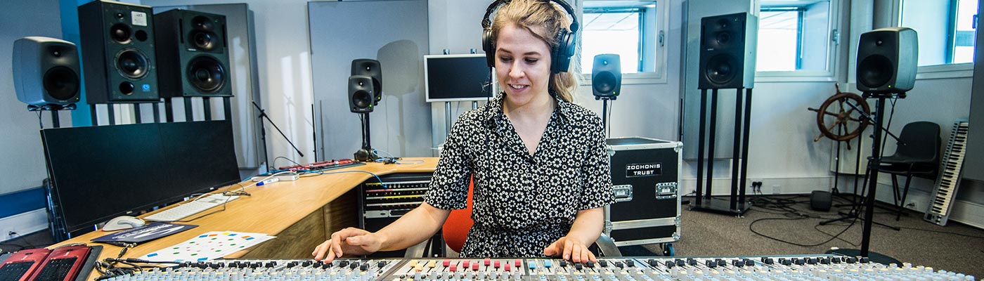 Female student at a mixing desk in the electroacoustic building