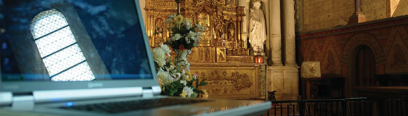 A laptop reflecting a church window in the screen