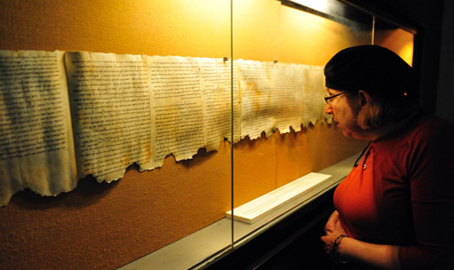 Woman standing in front of scrolls in display cabinet