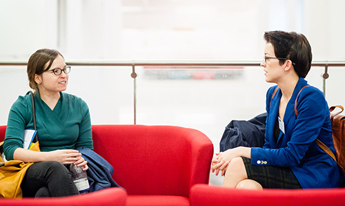 Two students talking on a couch