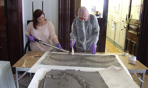 Woman wearing protective clothing whilst working on artwork