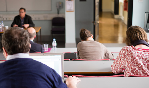 People in a classroom listening to tutor